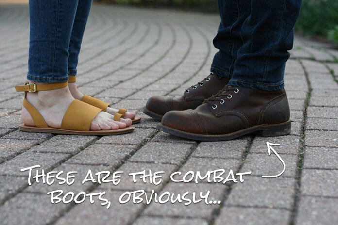 man wearing combat boots facing woman wearing sandals 
