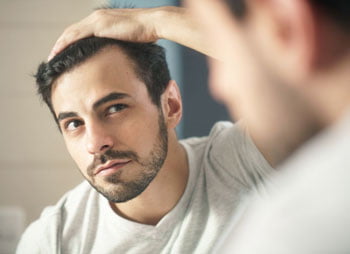 A man reviewing his haircut in the mirror