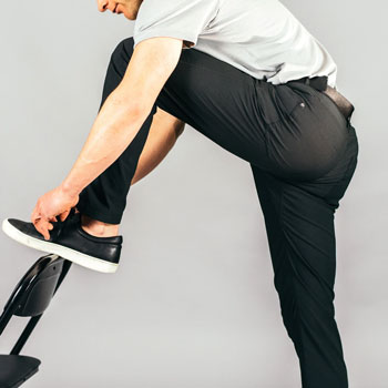 Man stretching to tie shoot wearing Western Rise Evolution pants