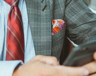Man with pocket square using phone