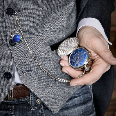 A man checking a pocket watch with a blue watch face