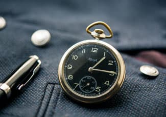 Gold pocket watch with black watch face