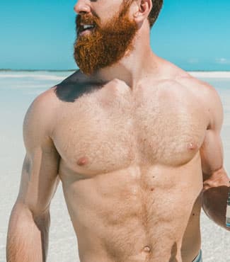 Muscular man with beard on beach