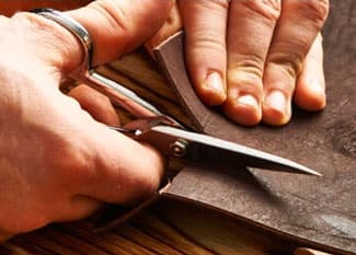 Tailor cutting leather 