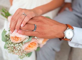 Bride and groom wearing wedding rings 