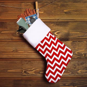 Stocking hanging against a wooden wall with gifts spilling out