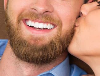 Woman kissing a bearded man