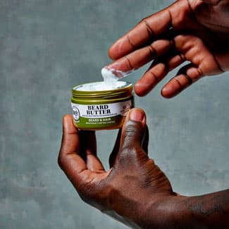 Black man putting beard butter on his fingers