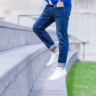 man wearing jeans and sneakers jumping on stairs