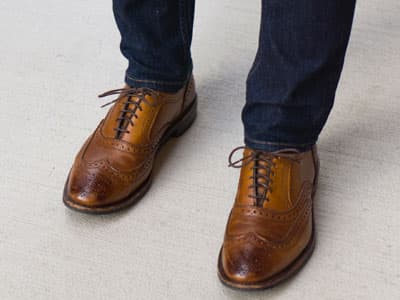 man wearing jeans and wingtip shoes