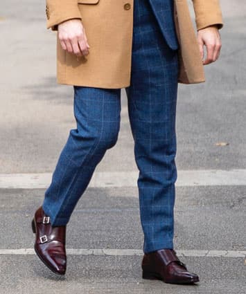 Man wearing brown monk strap shoes with blue pants