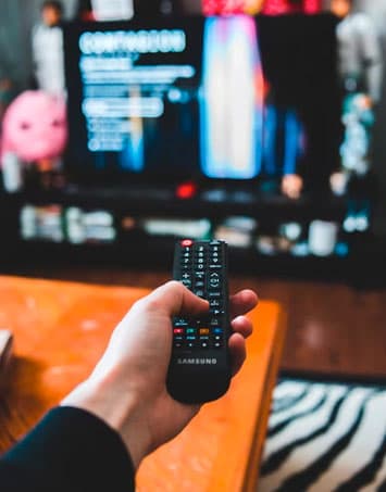 Man pointing remote control at tv