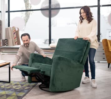 A man and woman shopping for a comfortable recliner 
