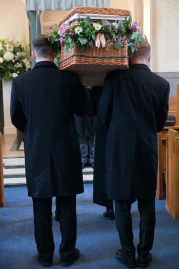Men carrying a casket at a funeral 