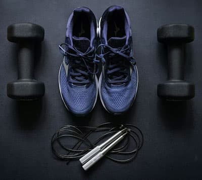 athletic shoes surrounded by weights