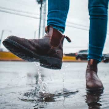 Chelsea boots splashing in puddle