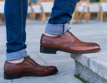 Man wearing jeans and brown brogues