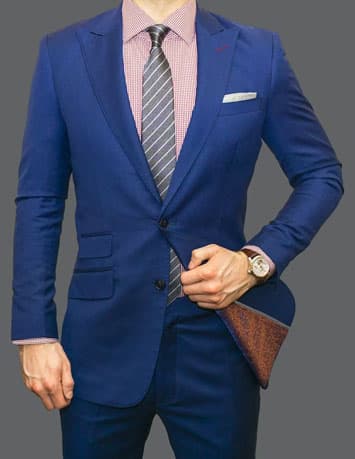A man wearing a blue suit with a pink shirt 