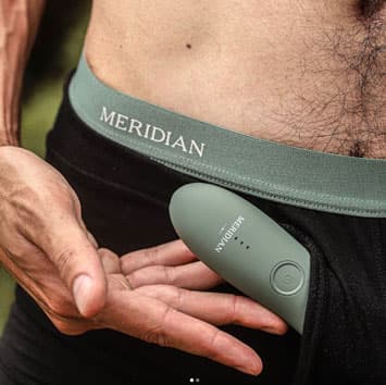 Man holds a Meridian pubic hair trimmer in his boxer briefs