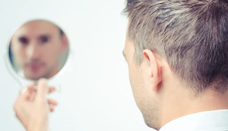 Man looking at face in mirror