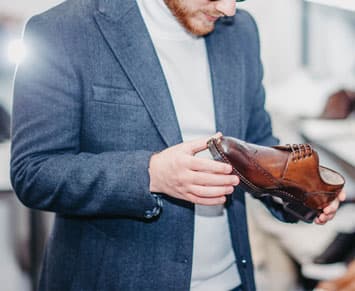 Man inspecting a brown leather dres shoe