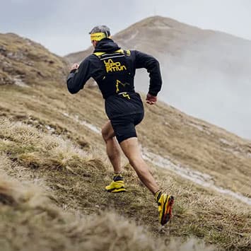 Man running up a hill wearing La Sportiva
