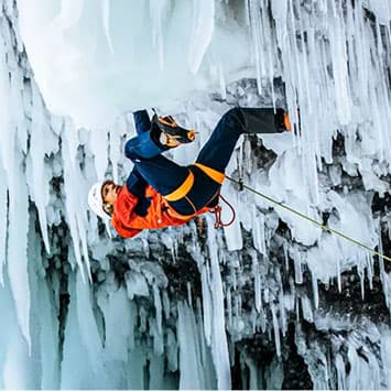 Man ice climbing in Mountain Hardwear gear 