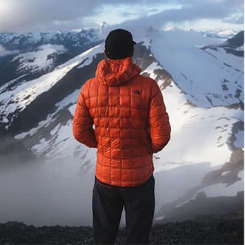 Man in North Face jacket looking at mountains