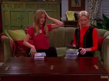 Screenshot from Friends with Rachel and Phoebe looking at Pottery Barn apothecary table