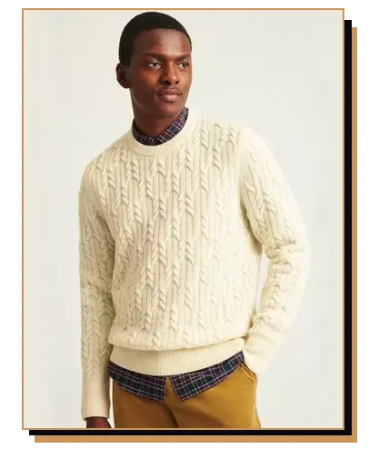 Man wearing a cream-colored cable knit sweater