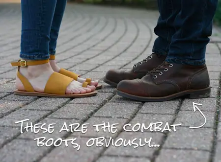 Close up on feet of woman wearing sandsals and man wearing combat boots
