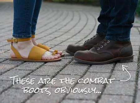 Close up on feet of woman wearing sandsals and man wearing combat boots 