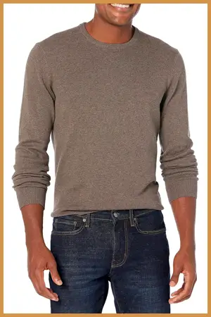 Man wearing a beige crew neck sweater and jeans