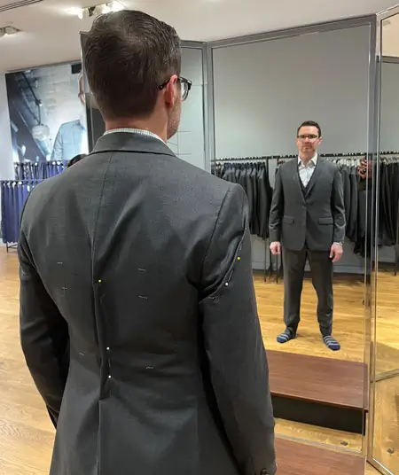 Shot from behind showing Irreverent Gent founder Dave Bowden wearing a pinned jacket during Indochino fitting