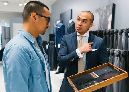 A sales clerk helping a customer at Indochino