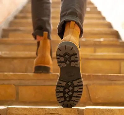 Man wearing lug tread boots walking up stairs
