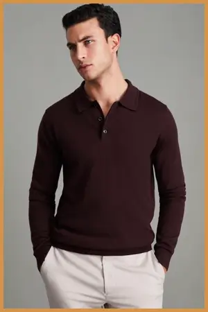 Man wearing a brown long sleeve polo sweater and white pants