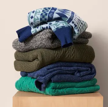 A stack of folded up sweaters 
