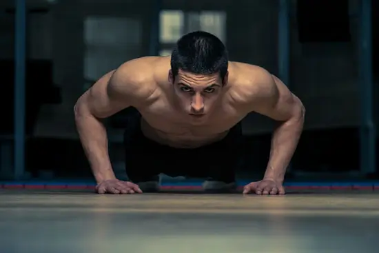 Man doing a pushup looking into camera