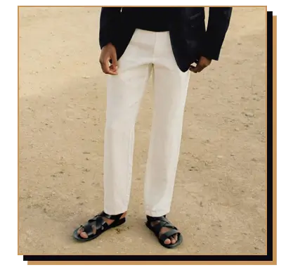Man wearing white pants and black leather sandals