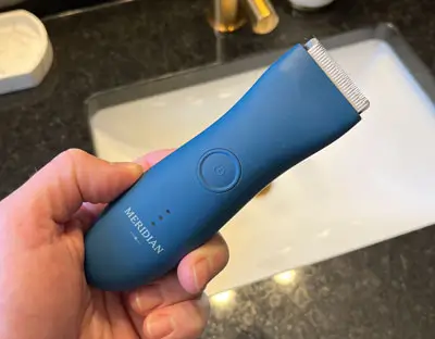 Hand holding a blue Meridian trimmer