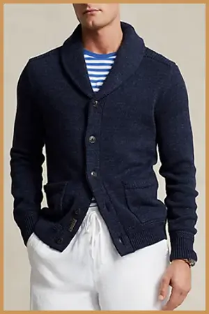 Man wearing navy blue shawl collar cardigan and white pants