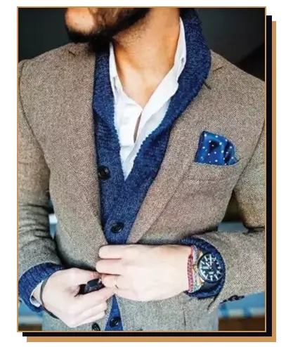 Man wearing blue shawl collar cardigan under brown blazer