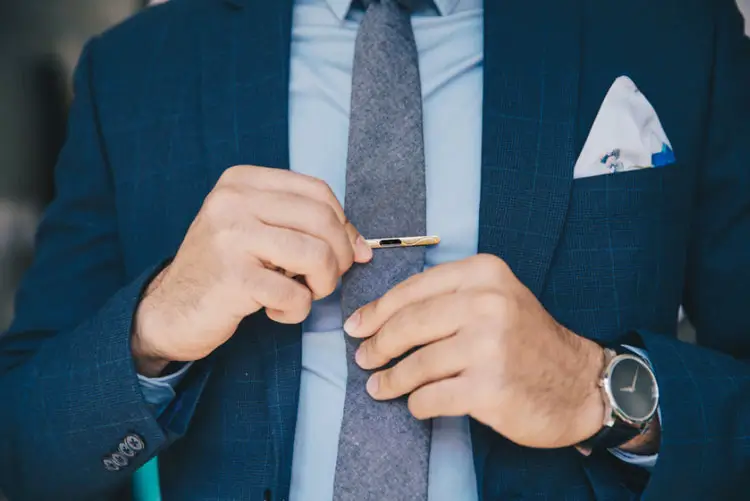 Man wearing blue suit and tie clip