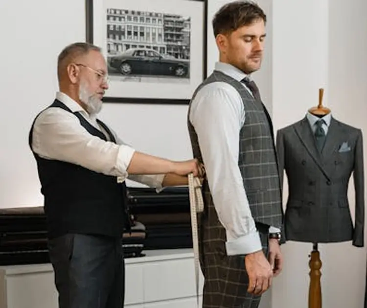 Tailor measuring man's suit
