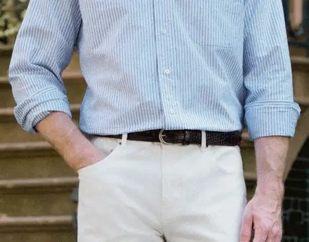 Man wearing blue shirt and dark brown leather belt