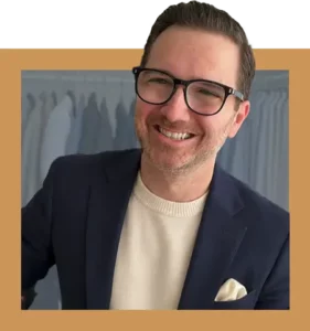 Dave-Bowden-Irreverent-Gent-Founder Dave Bowden, founder and chief editor of Irreverent Gent, wearing a navy blazer, cream sweater, and glasses.