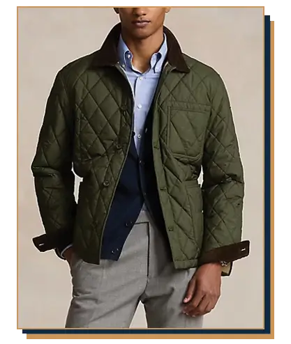 Man wearing an olive green quilted jacket with a corduroy collar from Ralph Lauren, layered over a navy vest, light blue dress shirt, and grey trousers.