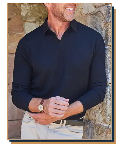 Man wearing a long-sleeve black sweater polo with a Johnny collar paired with off-white pants and a dark leather belt