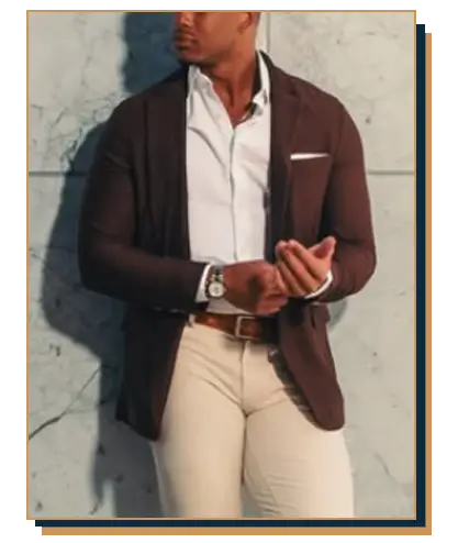Man wearing a dark brown blazer over an open-collar white dress shirt, paired with beige trousers, a brown leather belt, and a dress watch.